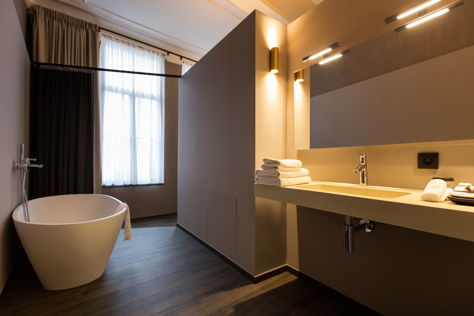 Badkamer van de suite met vrijstaand bad en warme verlichting